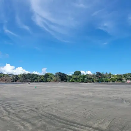 A wide, empty beach at low tide