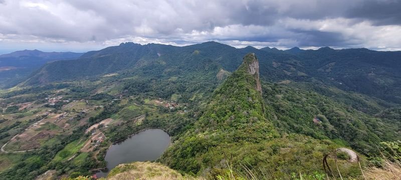 Green mountain ridges and a small lagoon seen from a summit in Panama